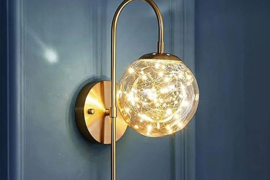 أبليك جداري عصري بشاسية ذهبي وكرة إضاءة داخلية تمنح جدارك شكلاً فاخراً وإضاءة دافئة مبهرة.