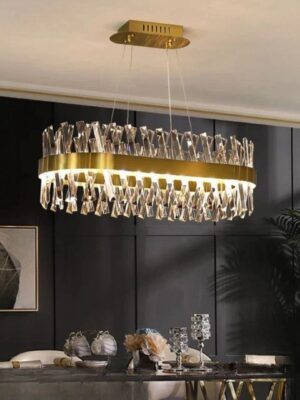 نجفة مستطيلة مذهّبة مزينة بكريستالات فاخرة بلمعان قوي، مناسبة لغرف السفرة والديكورات الفاخرة.