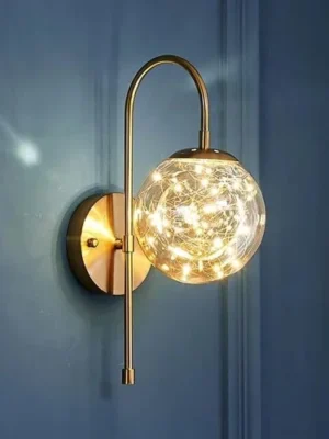 أضف لمسة من الأناقة إلى مساحتك مع هذا الأبليك الحائطي الذهبي العصري، الذي يتميز بقاعدة معدنية أنيقة وكرة زجاجية متوهجة. متوافق مع كلٍ من لمبات LED واللمبات المتوهجة، مما يجعله مثاليًا لأي غرفة في منزلك.